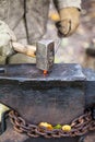 Blacksmith forges hot iron rod with sledgehammer Royalty Free Stock Photo