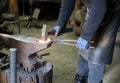 A blacksmith forges iron parts.