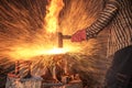 Blacksmith forging the molten metal with a hammer to make keris Royalty Free Stock Photo