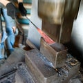 Blacksmith forging by using pneumatic hammer.