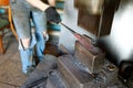 Blacksmith forging by using pneumatic hammer.