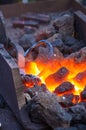 blacksmith furnace with burning coals, tools, and glowing hot metal workpieces Royalty Free Stock Photo