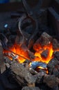 blacksmith furnace with burning coals, tools, and glowing hot metal workpieces Royalty Free Stock Photo