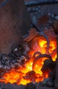 blacksmith furnace with burning coals, tools, and glowing hot metal workpieces Royalty Free Stock Photo