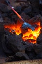 blacksmith furnace with burning coals, tools, and glowing hot metal workpieces Royalty Free Stock Photo