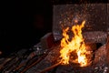 Blacksmith furnace with burning fire and forging tools lying nearby Royalty Free Stock Photo