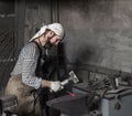 Blacksmith hammering a hot metal rod Royalty Free Stock Photo