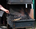 Blacksmith heating workpiece in coke fired forge. Royalty Free Stock Photo