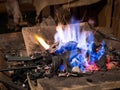 Blacksmith heats the iron on the furnace fire Royalty Free Stock Photo