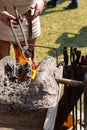 Blacksmith holds long nippers over fire heats metal sword manufacturing marching forge