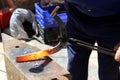 Blacksmith making a horseshoe from heated red rod Royalty Free Stock Photo