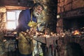 Blacksmith manually forging the molten metal on the anvil in