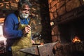 Blacksmith manually forging the molten metal