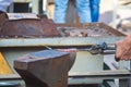 blacksmith performs the forging of hot glowing metal on the anvil