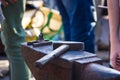 blacksmith performs the forging of hot glowing metal on the anvil