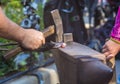 blacksmith performs the forging of hot glowing metal on the anvil