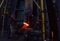 Blacksmith processes the iron product under a huge press, forging metal, stamping. Royalty Free Stock Photo