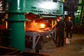 Blacksmith processes the red hot iron under a huge press. Metal forging, stamping under hammer forge at workshop of forge foctory