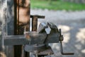 Blacksmith`s clamp. Metal clamping device on an old workbench. Vise desktop