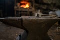 A blacksmith`s hammer lies on an anvil against the background of a burning forge Royalty Free Stock Photo