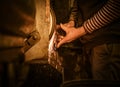 The blacksmith sharpening an ax on electrical grinder