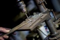 Blacksmith uses drill press in garage. A close up view of a metalworker operating a bench drill inside his workshop.