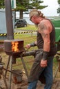 Blacksmith working outdoors with small forge
