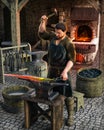 Blacksmith at work outside his shop in a medieval European village Royalty Free Stock Photo