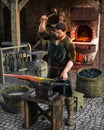 Blacksmith at work outside his shop in a medieval European village