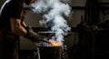 Blacksmith working with fire and smoke in a dark workshop Royalty Free Stock Photo