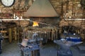 Blacksmith working at his forge with metal in white flame