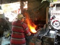 Blacksmith working in workshop at street level