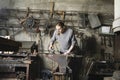 Blacksmith Working In Workshop