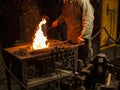 A blacksmith works with open fire