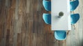 a Blackwalnut floor meeting a white island table, accented by sleek blue chairs, with light brown and gray ceramics