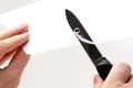 Blade of a sharp knife cut across the white paper Royalty Free Stock Photo