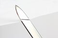 Blade of a sharp knife cut across the white paper Royalty Free Stock Photo