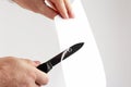 Blade of a sharp knife cut across the white paper Royalty Free Stock Photo
