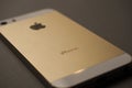 Close-up of the golden back cover of a smartphone with the inscription iPhone