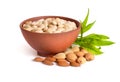Blanched almonds In a bowl with unshelled nuts. On white background.