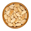 Blanched and roasted almonds, whole seeds, in a wooden bowl