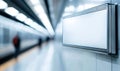 Blank advertisement billboard on a subway platform, with blurred passengers and bright overhead lighting. Royalty Free Stock Photo
