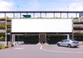 Blank advertising large billboard banner mockup, outside multi-storey carpark with eco green wall, above entrance. Large digital