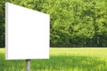 Blank advertising signboard in a countryside with forest in the background - concept with space for inserting text