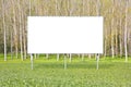 Blank advertising signboard in a countryside with forest in the background - concept with space for inserting text