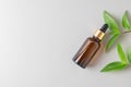 Blank amber glass essential oil bottle on gray background. Natural organic cosmetics, alternative medicine, sustainable lifestyle Royalty Free Stock Photo