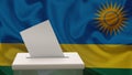 Blank ballot with space for text or logo is dropped into the ballot box against the background of the flag of Rwanda. Election Royalty Free Stock Photo