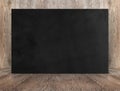 Blank banner black canvas poster leaning at wood wall on wooden Royalty Free Stock Photo