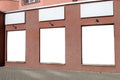 Blank banners in the window on the facade of a red building outdoors Royalty Free Stock Photo