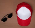 Blank baseball caps are used for design mockups. The hat on the side of an old camera and sunglasses. Royalty Free Stock Photo